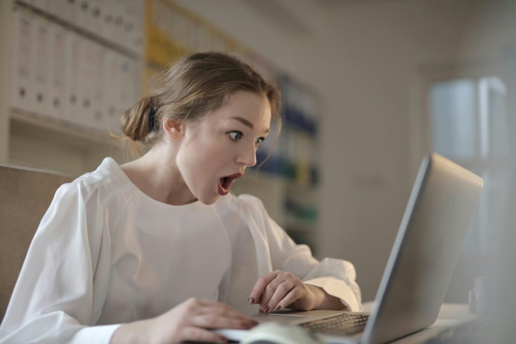 Why Mutual Respect is Important in Casual Hookups 3 Surprised woman sitting at desk with laptop indoors, expressing amazement.