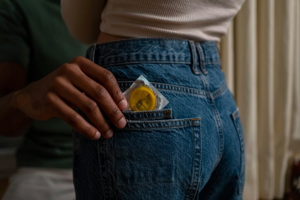 Ground Rules for People Getting into Casual Sex for the First Time 3 Condom being placed into denim jeans pocket, emphasizing safe sex and contraceptive use.