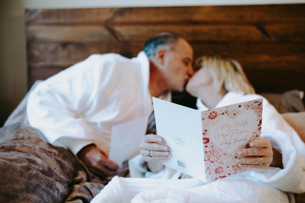 What Men View as a Perfect Casual Sex Partner 3 Senior couple shares an intimate moment with a romantic card indoors, showcasing love and companionship.