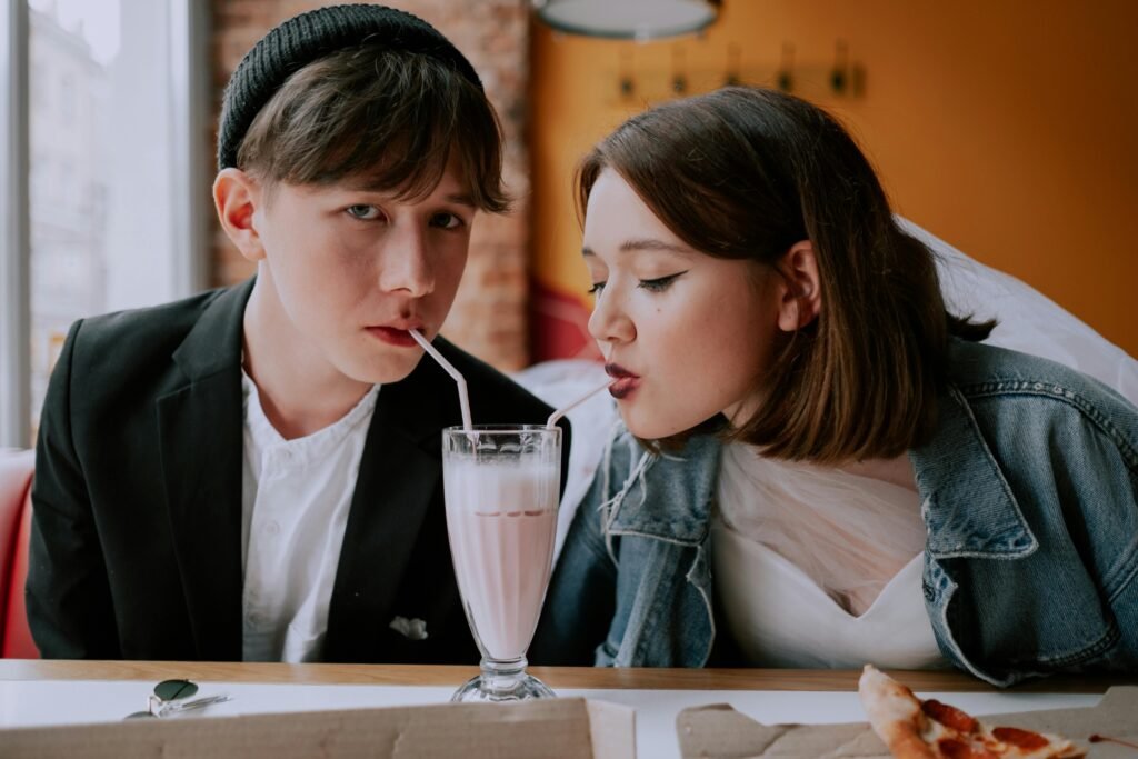 Top 10 Tips for a Safe Hookup 3 A young couple shares a milkshake in a cozy café, enjoying the moment together.